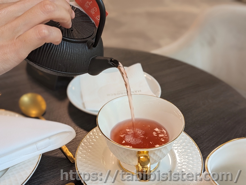 急須から注がれるオレンジ色の紅茶